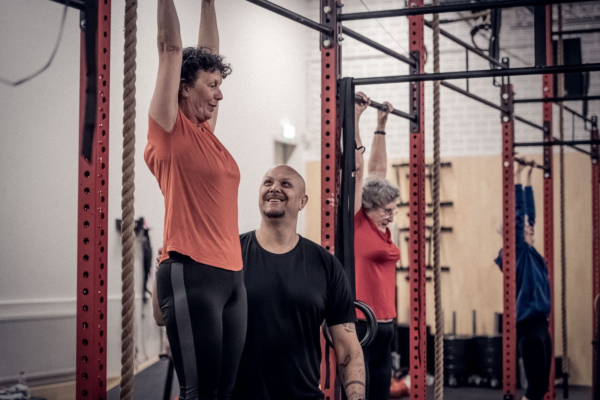 Coach en lid lachen samen voor de WOD